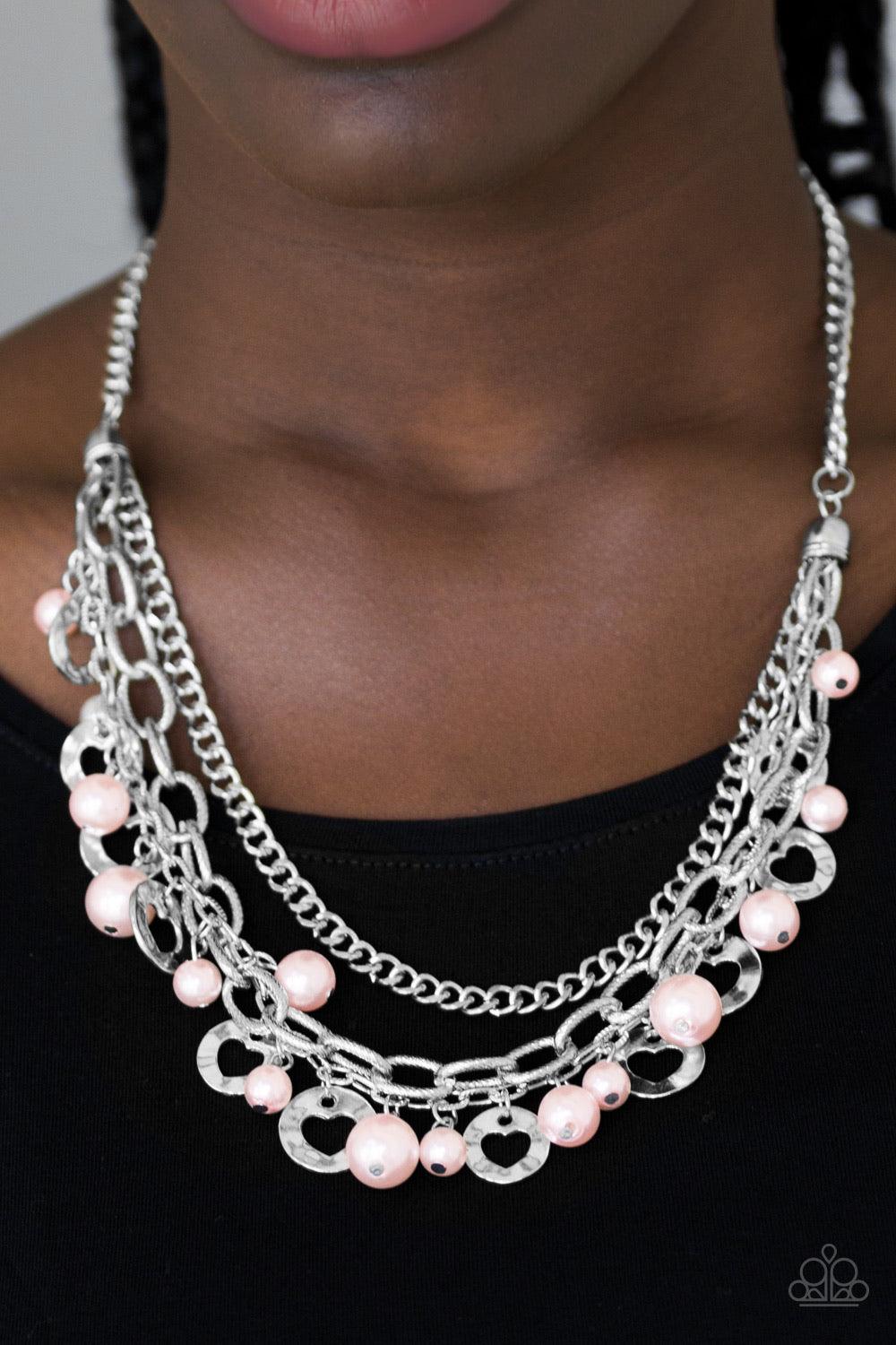 Paparazzi Accessories Hoppin Hearts - Pink Three rows of mismatched silver chains layer below the collar. Infused with airy heart cut-out centers, delicately hammered silver discs and pearly pink beads swing from the bottom of the lowermost chain, creatin