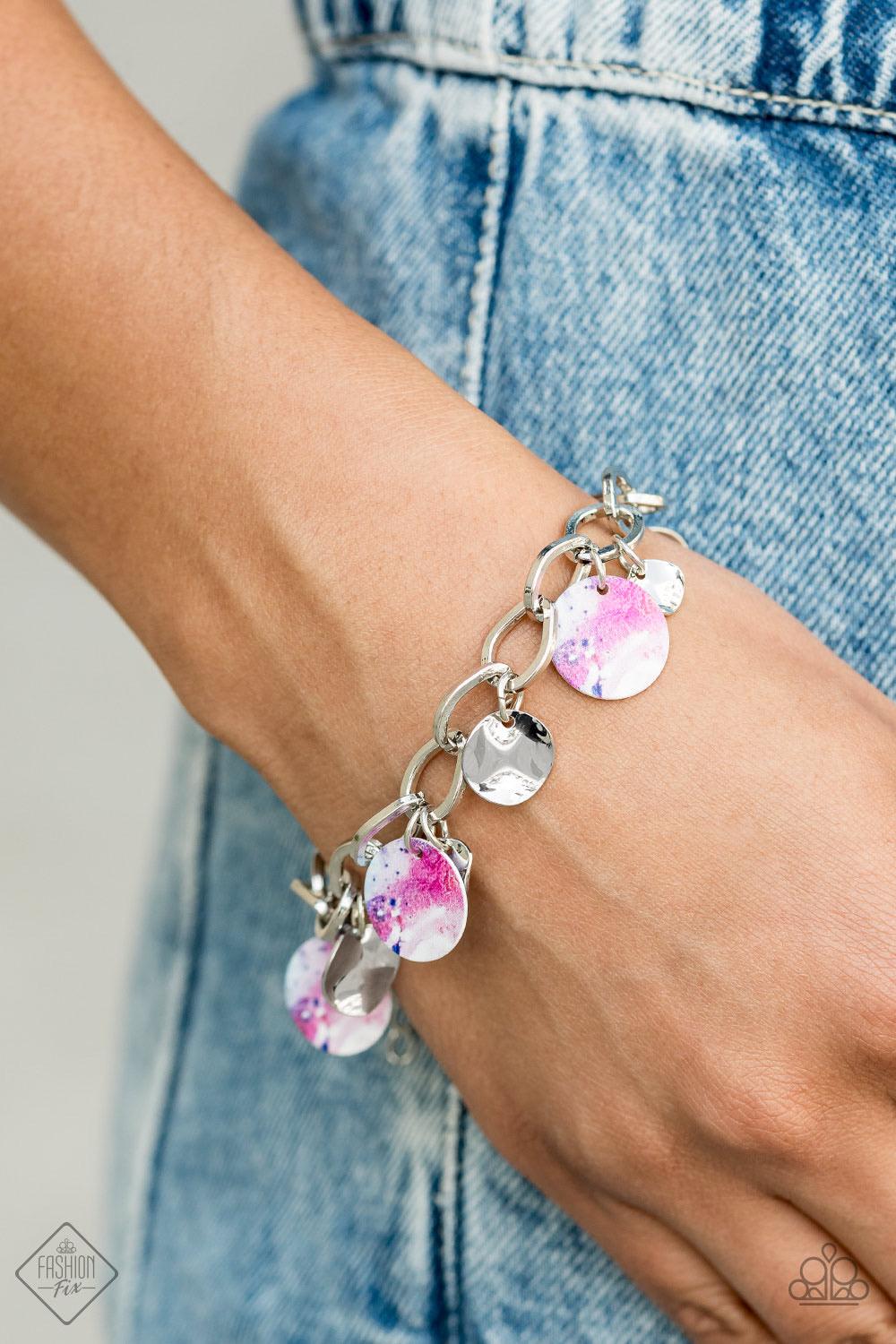 Paparazzi Accessories Teasingly Tie Dye ~Multi Featuring a galactic tie dye print, a collection of colorful and dainty silver discs swings from a bulky silver chain around the wrist for a trendy finish. Features an adjustable clasp closure. Sold as one in