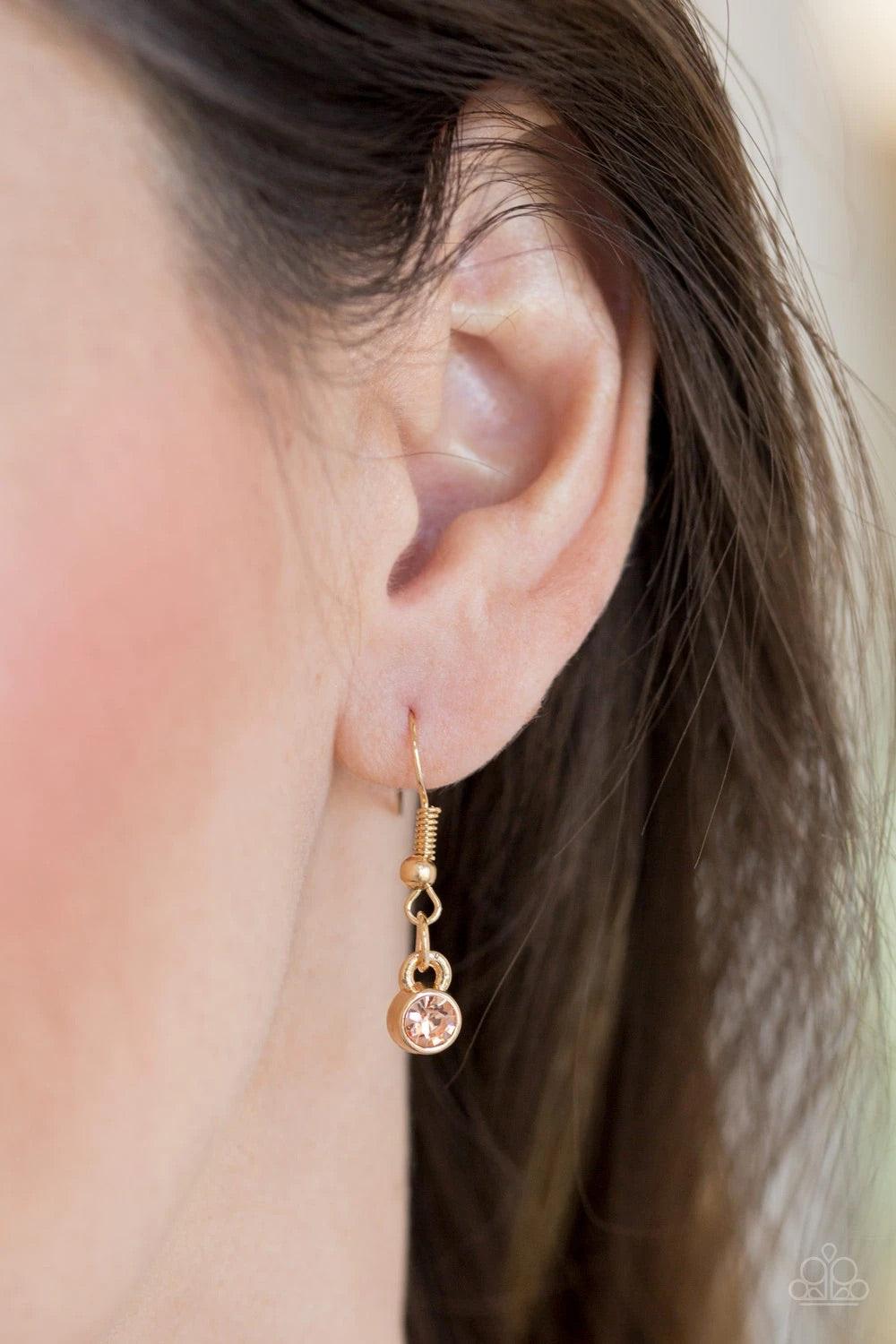 Paparazzi Accessories Timeless Trio - Gold Encrusted in radiant peach rhinestones, three gold hoops interlock at the bottom of an elongated gold chain for an elegant look. Features an adjustable clasp closure. Sold as one individual necklace. Includes one