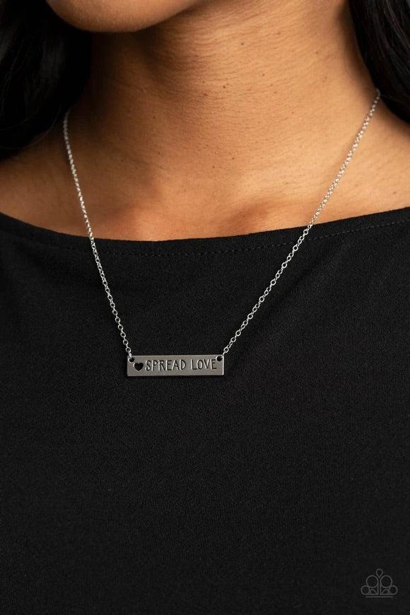Paparazzi Accessories Spread Love - Silver Featuring a dainty heart cutout, a shiny silver plate is stamped in the phrase, "Spread Love," creating an inspirational phrase below the collar. Features an adjustable clasp closure. Sold as one individual neckl