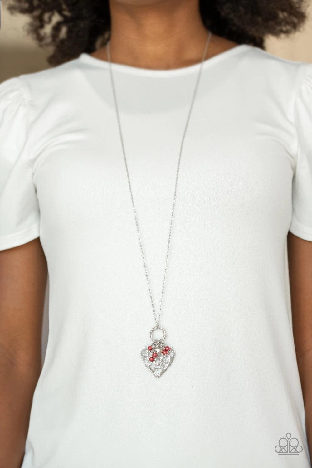 Paparazzi Accessories Romeo Romance - Red Infused with dainty red pearls and a shimmery silver heart charm, a stenciled silver heart pendant swings from the bottom of a lengthened silver chain for a whimsical look. Features an adjustable clasp closure. So