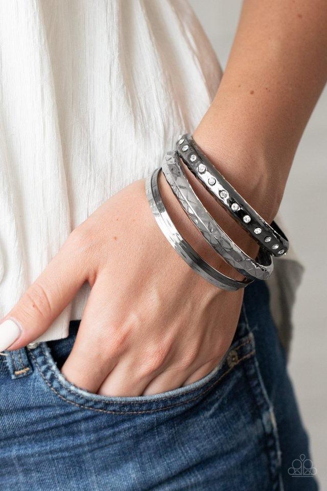 Paparazzi Accessories Revved Up Rhinestones - Multi A mismatched stack of gunmetal and silver bangles are hammered in texture, creating light-catching edges that reflect an immense amount of shine. One bangle is lined with glassy white rhinestones, adding