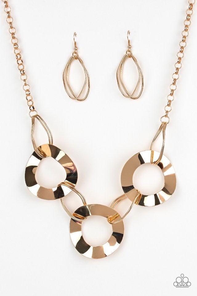 Paparazzi Accessories Modern Mechanics - Gold Featuring slightly warped surfaces, asymmetrical gold hoops link with reflective gold rings below the collar for a modern look. Features an adjustable clasp closure. Sold as one individual necklace. Includes o