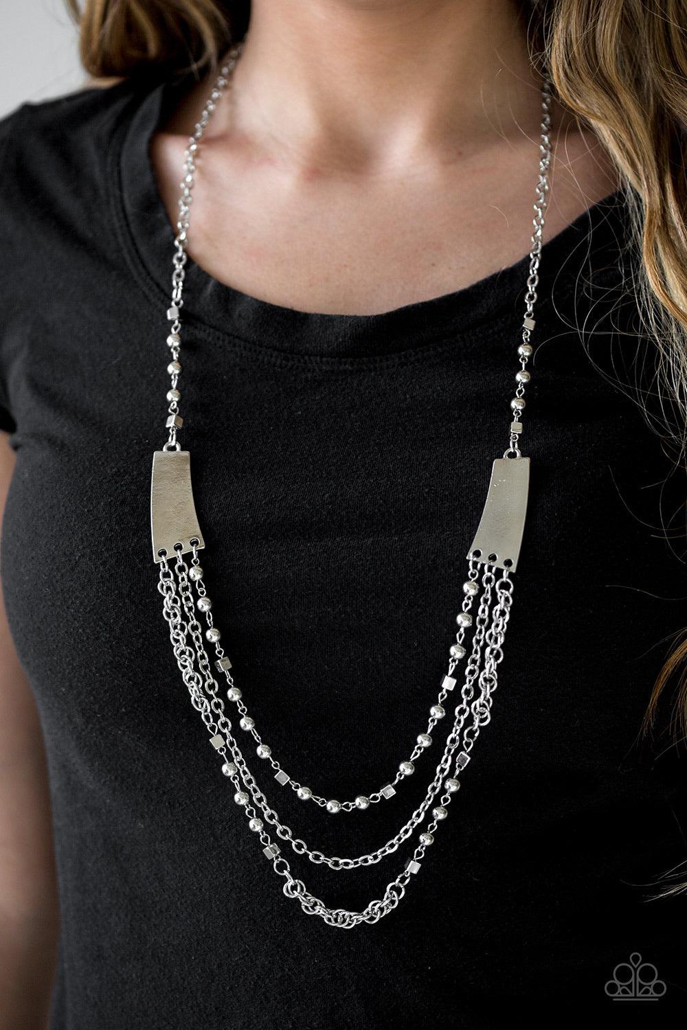 Paparazzi Accessories Marvelously Metro - Silver Varying in shape and shimmer, three glistening silver chains stream from the bottom of two silver plates. Infused with round and square silver accents, the mishmash of chains layer down the chest in a bold