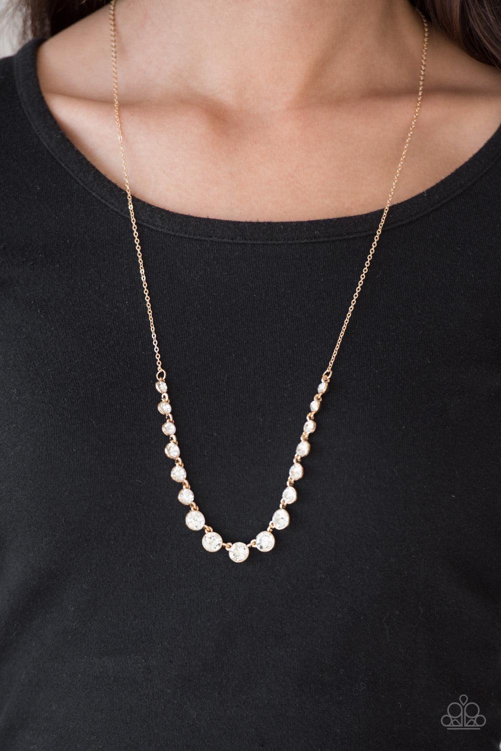 Paparazzi Accessories Here We GLOW! - Gold Gradually increasing in size towards the center, glittery white rhinestones link across the bottom of an elegantly elongated gold chain for a timeless look. Features an adjustable clasp closure. Jewelry