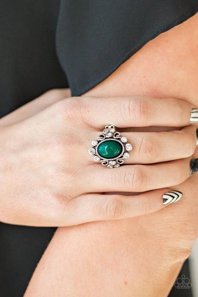 Paparazzi Accessories Noticeable Notable - Green A polished green bead is pressed into a bubbly silver frame radiating with glassy white rhinestones for a notable finish. Features a stretchy band for a flexible fit. This hunter green ring is perfect for t