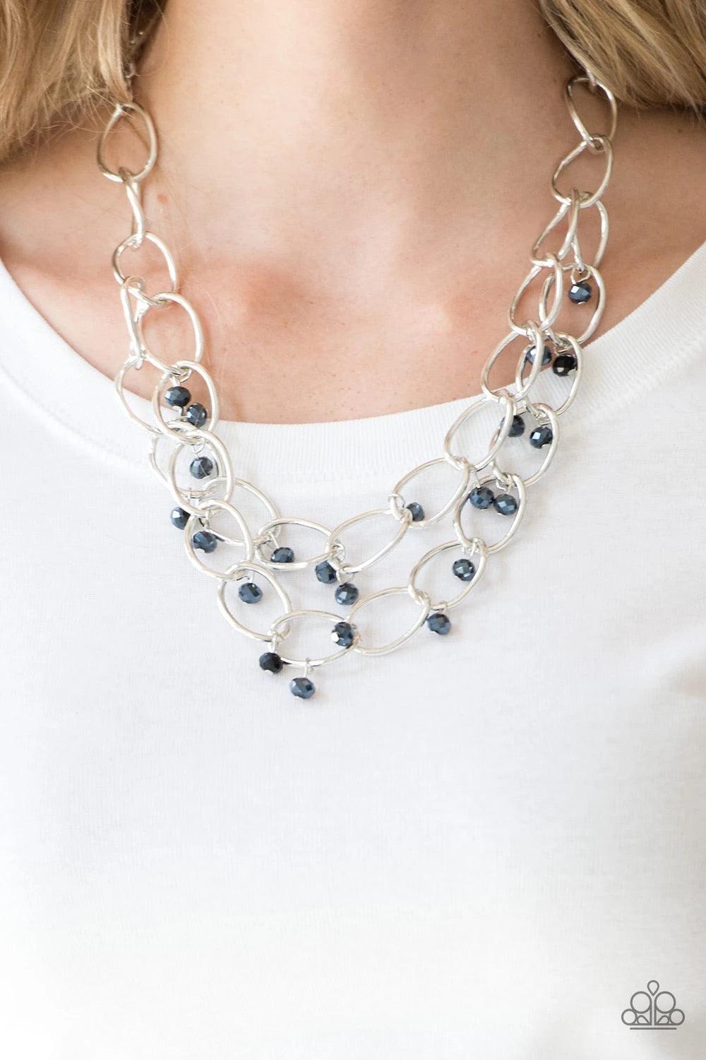 Paparazzi Accessories Yacht Tour - Blue Metallic blue crystal-like beads swing from two layers of oversized silver links below the collar for a refined look. Features an adjustable clasp closure. Sold as one individual necklace. Includes one pair of match