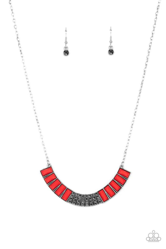 Paparazzi Accessories Coup de MANE - Red Stacked rows of hematite rhinestones and faceted emerald cut Fire Whirl beads coalesce into a colorful half moon pendant, creating a flamboyant pop of color below the collar. Features an adjustable clasp closure. S