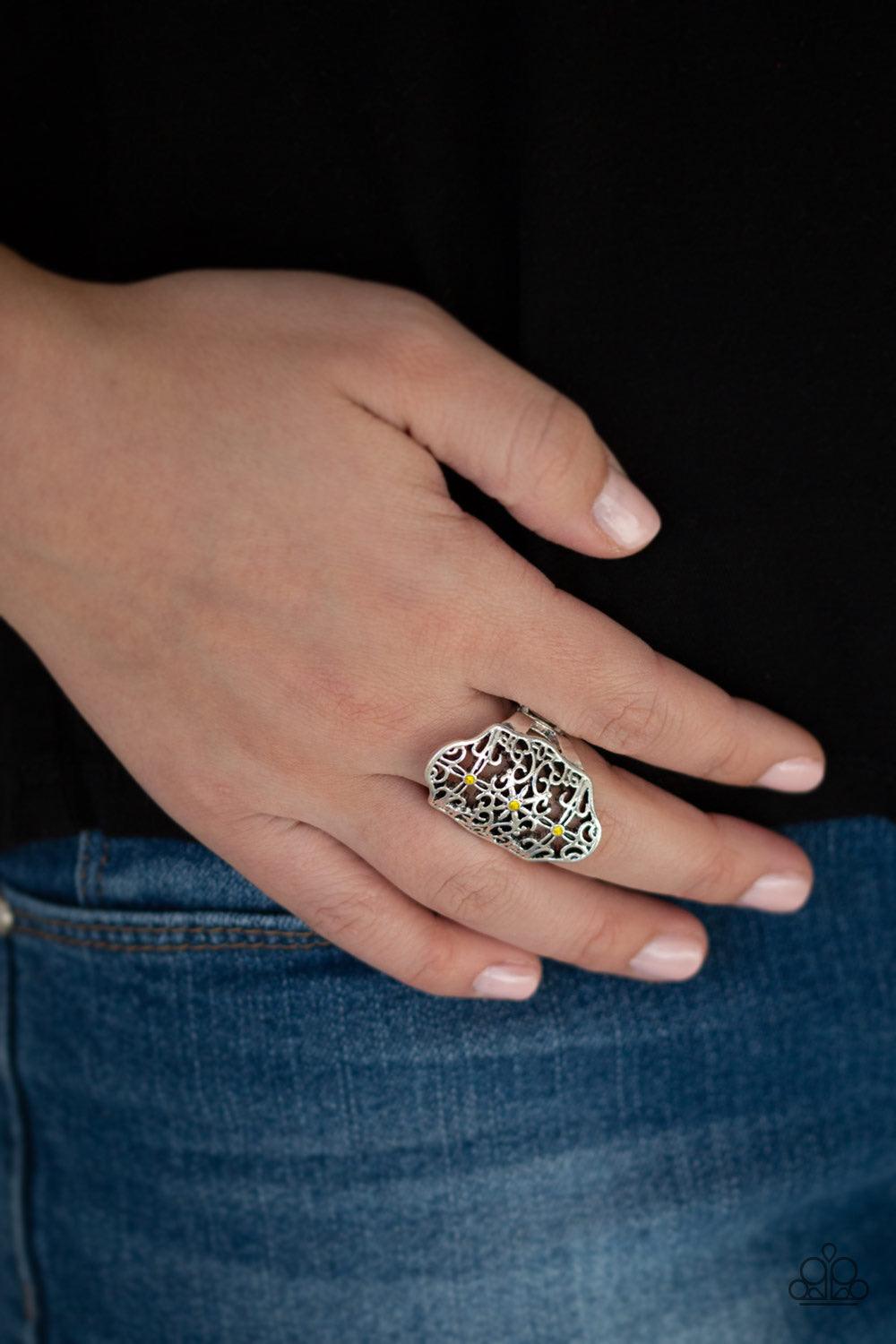 Paparazzi Accessories Botanical Beam - Yellow Glistening silver filigree swirls into a floral textile pattern across the finger. Glittery yellow rhinestones and dainty silver studs are sprinkled across the ornate silver frame for a whimsical finish. Featu