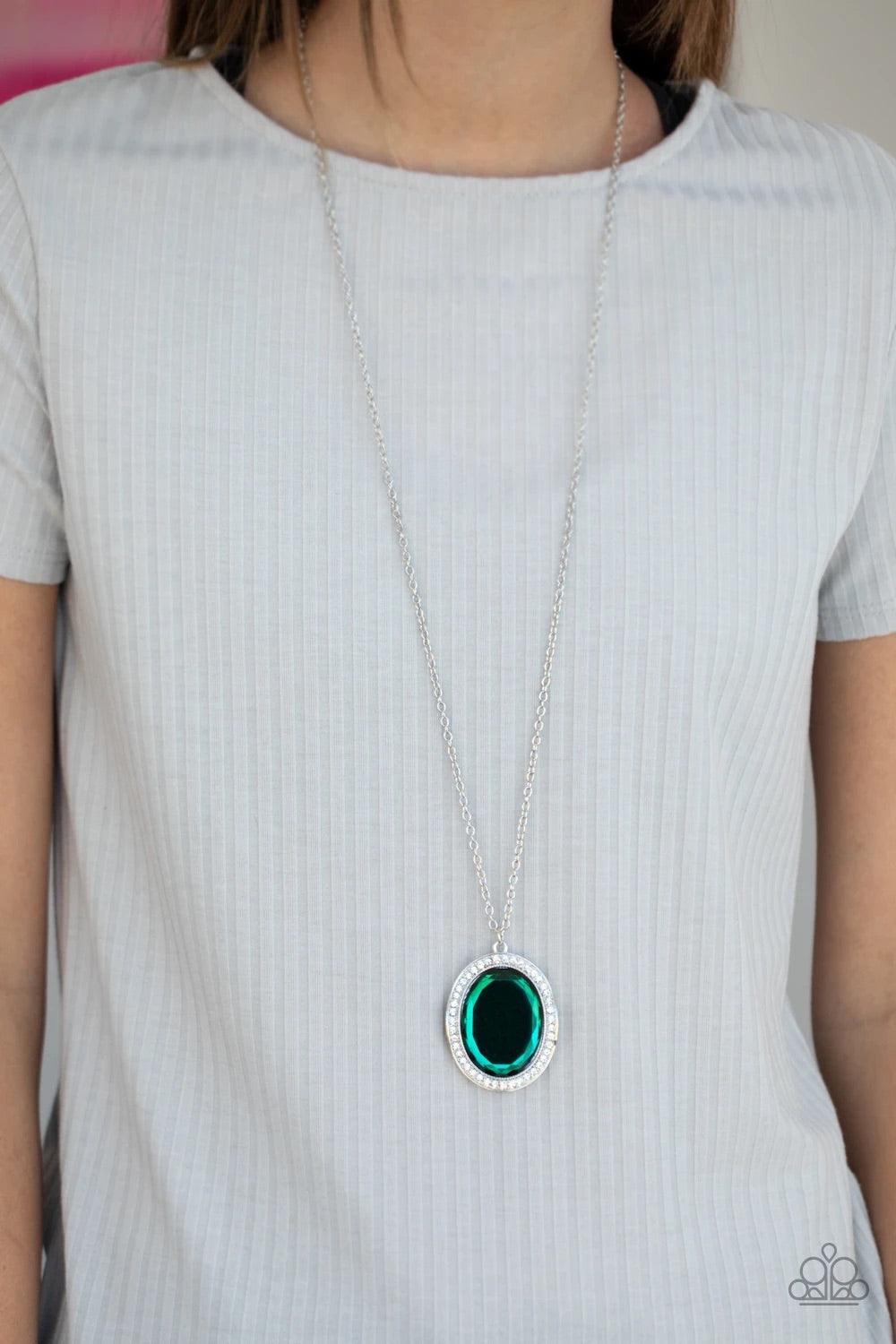 Paparazzi Accessories REIGN Them In - Green A dramatically oversized green gem is pressed into the center of a curvy silver frame dusted in dainty white rhinestones, creating a glamorous pendant at the bottom of a lengthened silver chain. Features an adju
