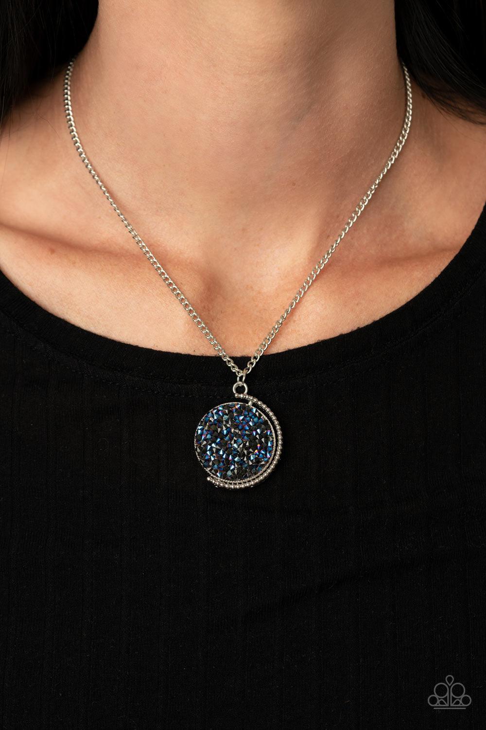 Paparazzi Accessories My Moon And Stars - Blue A smoldering collision of black and metallic blue rhinestones are encrusted across the front and back of a textured silver disc below the collar. Threaded along a dainty rod, the glittery pendant effortlessly