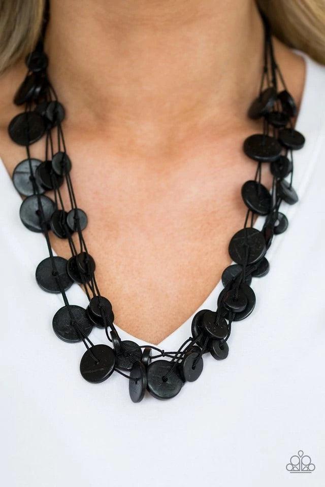 Paparazzi Accessories Bermuda Beach House - Black Tinted in a black finish, distressed wooden discs trickle along strands of knotted black cording, creating neutral layers below the collar for a seasonal vibe. Features a button-loop closure. Sold as one i