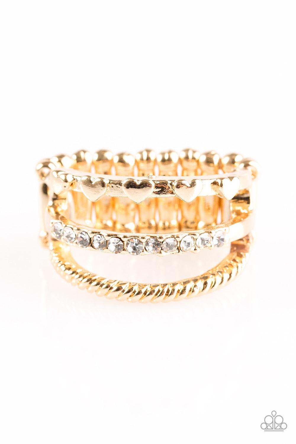 Paparazzi Accessories Dear To My Heart - Gold Three glistening gold bands arc across the finger. Dainty heart accents are pressed into the uppermost band, while glittery white rhinestones are encrusted along the centermost band and shimmery serrated textu