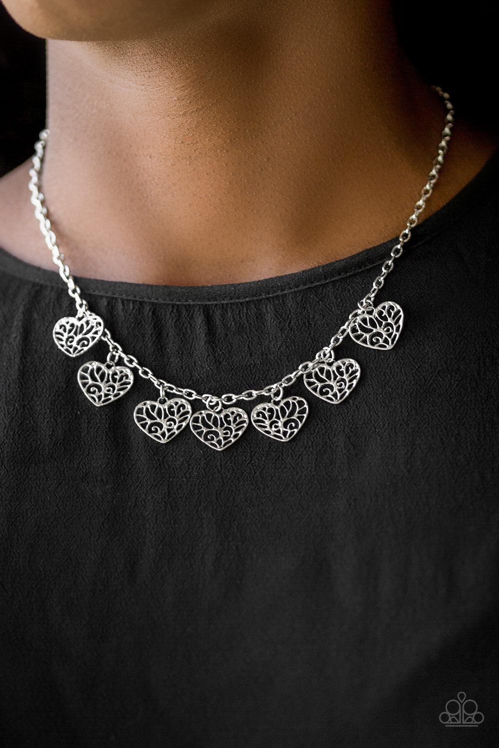 Paparazzi Accessories Less is AMOUR - Silver Infused with vine-like filigree filled centers, dainty silver hearts swing from the bottom of a shimmery silver chain below the collar for a whimsical look. Features an adjustable clasp closure. Sold as one ind