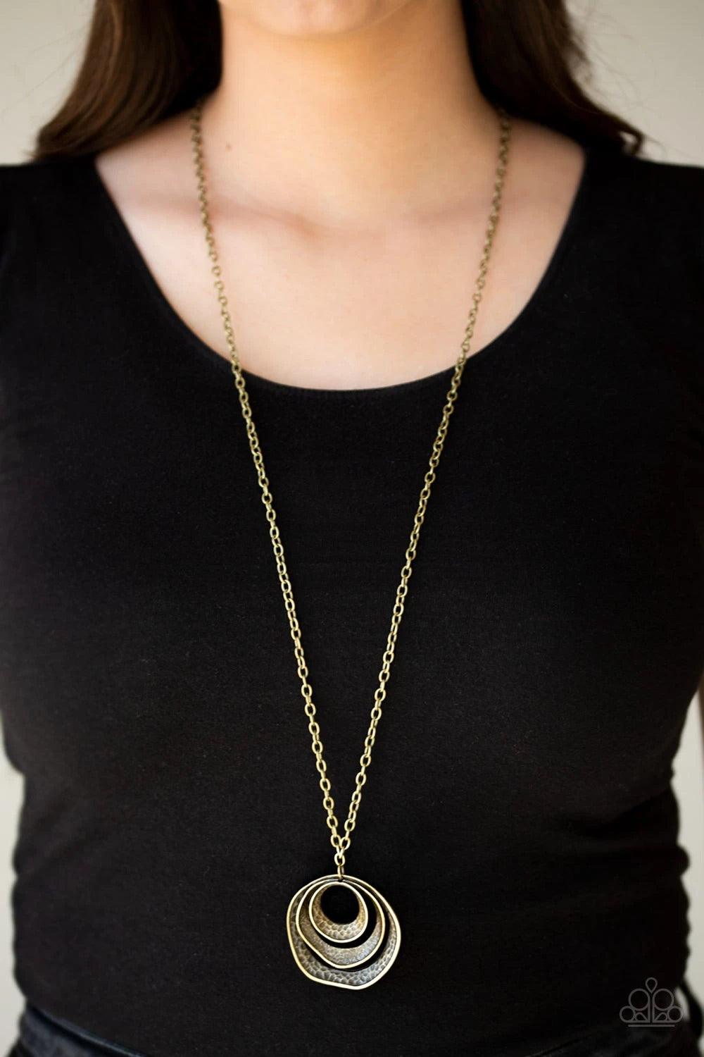 Paparazzi Accessories Breaking Pattern - Brass Hammered in an array of mismatched textures, three asymmetrical hoops join into an abstract pendant at the bottom of a lengthened brass chain for a handcrafted look. Features an adjustable clasp closure. Sold