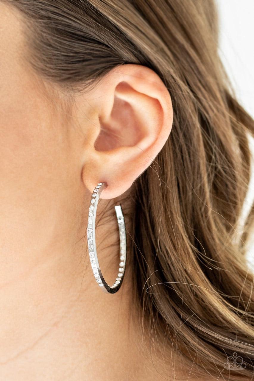 Paparazzi Accessories Comin’ Into Money - White The front half and inner backside of a sleek silver hoop is encrusted in glassy white rhinestones, easily catching and reflecting the light for an extra dash of shimmer. Earring attaches to a standard post f