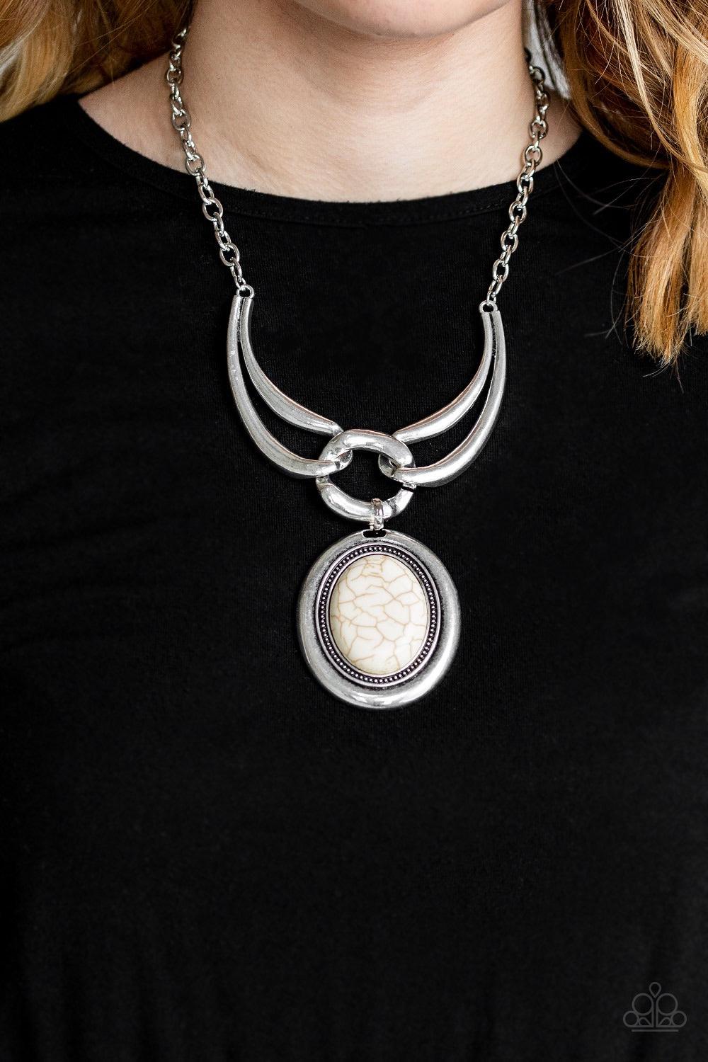 Paparazzi Accessories Divide And RULER - White Three handcrafted silver pieces connect below the collar in a bold artisan inspired fashion. Nestled in the center of a studded silver frame, an oversized white stone pendant swings from the bottom of the int
