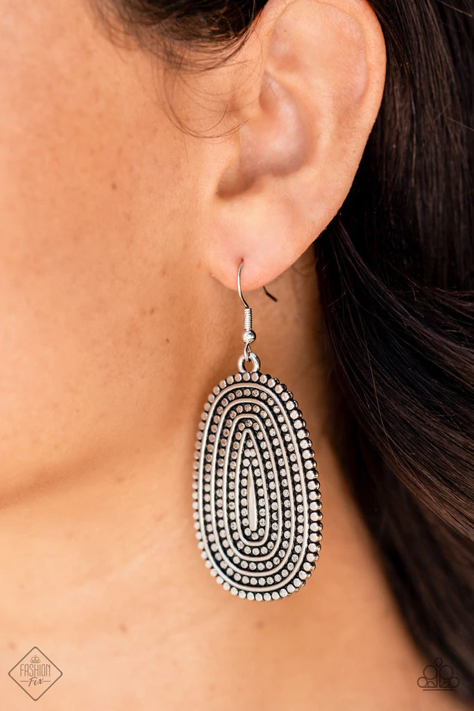 Paparazzi Accessories Desert Climate - Silver Rows of antiqued silver dotted texture radiate outward from an embossed center. The concentric lines create a rippling effect across the frame resulting in a rustic finish. Earring attaches to a standard fishh