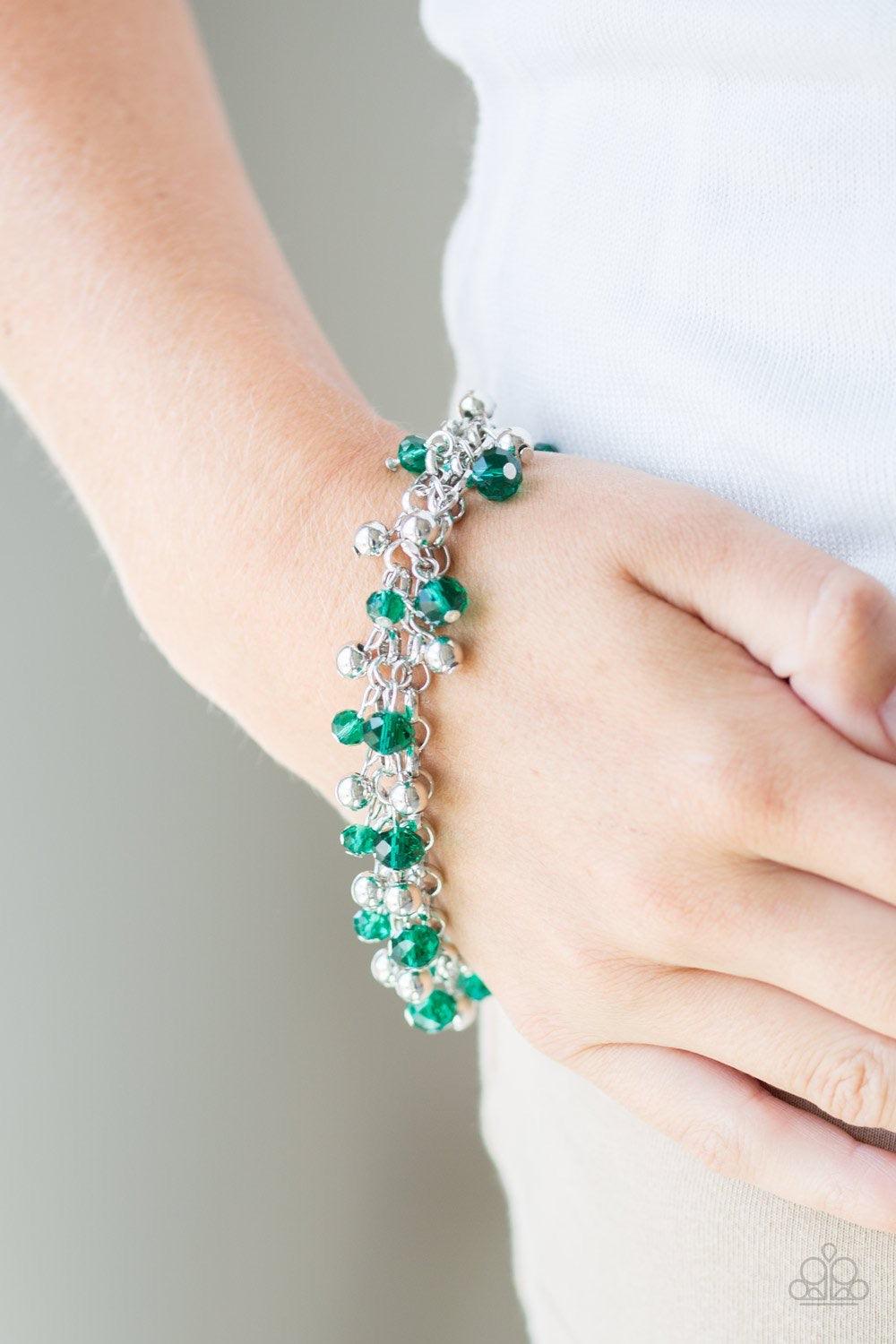 Paparazzi Accessories Just For The FUND Of It! - Green Faceted green crystal-like beads and classic silver beads swing from interlocking silver chains, creating a refined fringe around the wrist. Features an adjustable clasp closure. Jewelry