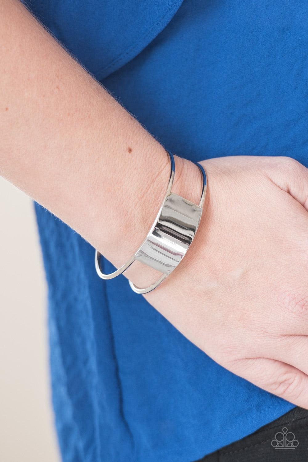 Paparazzi Accessories Set The SHEEN - Silver Glistening silver bars curl around the wrist, creating an airy cuff. Brushed in a high sheen finish, a shimmering silver frame adorns the center of the cuff for an edgy finish. Jewelry