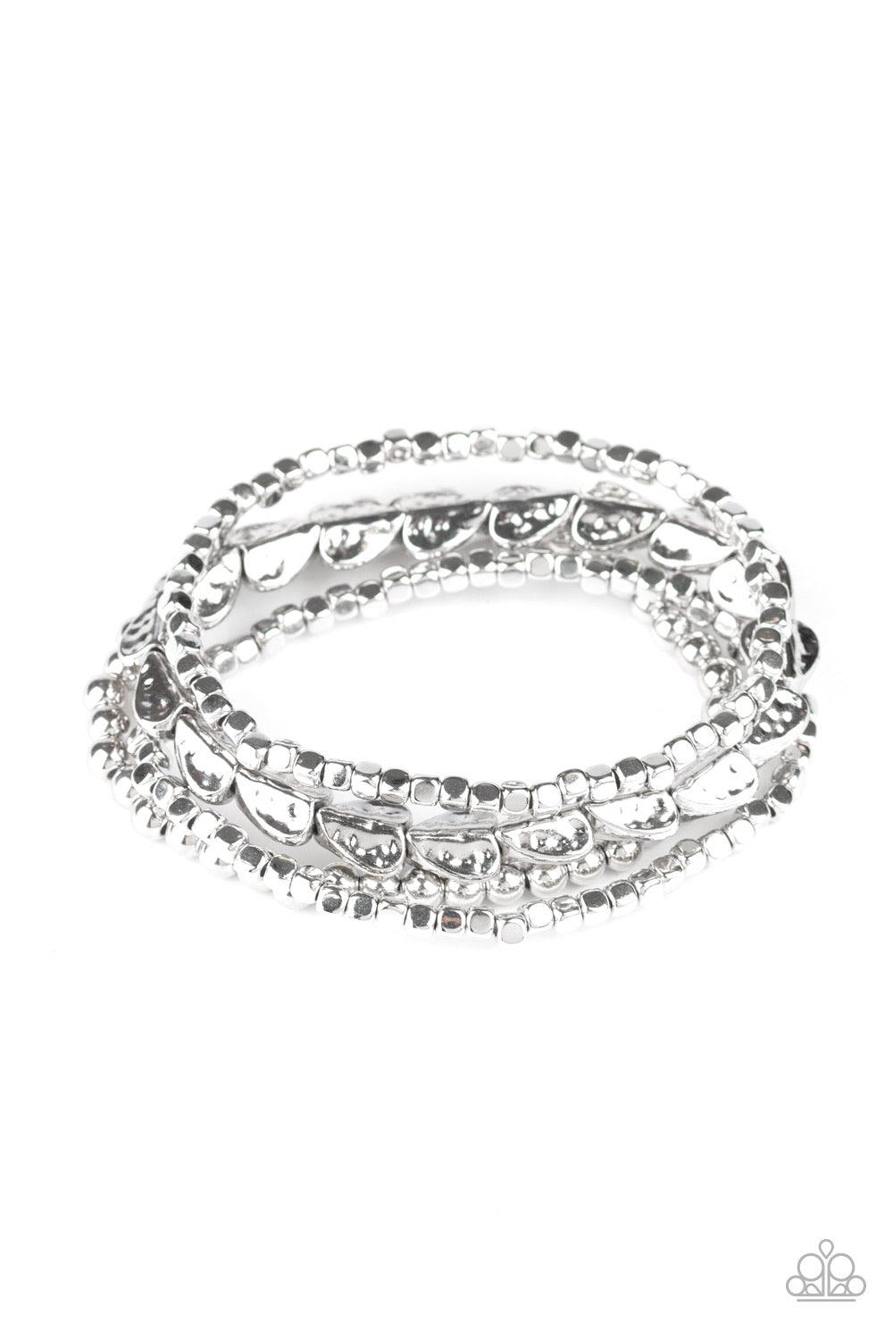 Paparazzi Accessories Ancient Heirloom - Silver A collection of silver cubes, classic silver beads, and hammered spade-like beading is threaded along stretchy bands around the wrist for a boldly stacked look. Jewelry