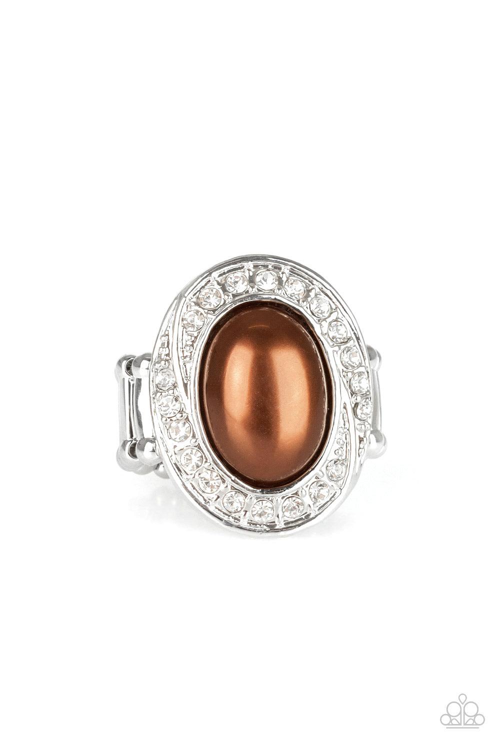 Paparazzi Accessories The ROYALE Treatment - Brown A pearly brown bead is pressed into a silver oval frame radiating with a ring of glittery white rhinestones, creating a regal statement piece atop the finger. Features a stretchy band for a flexible fit.