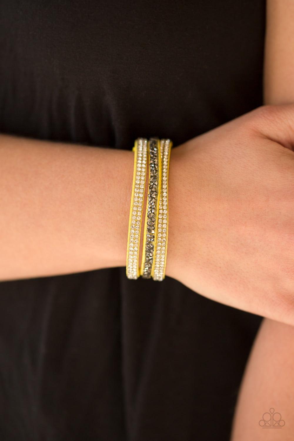 Paparazzi Accessories Mega Glam - Yellow Glittery white and glassy hematite rhinestones are sprinkled along three strands of bright yellow suede for a glamorous look. Features an adjustable snap closure. Jewelry
