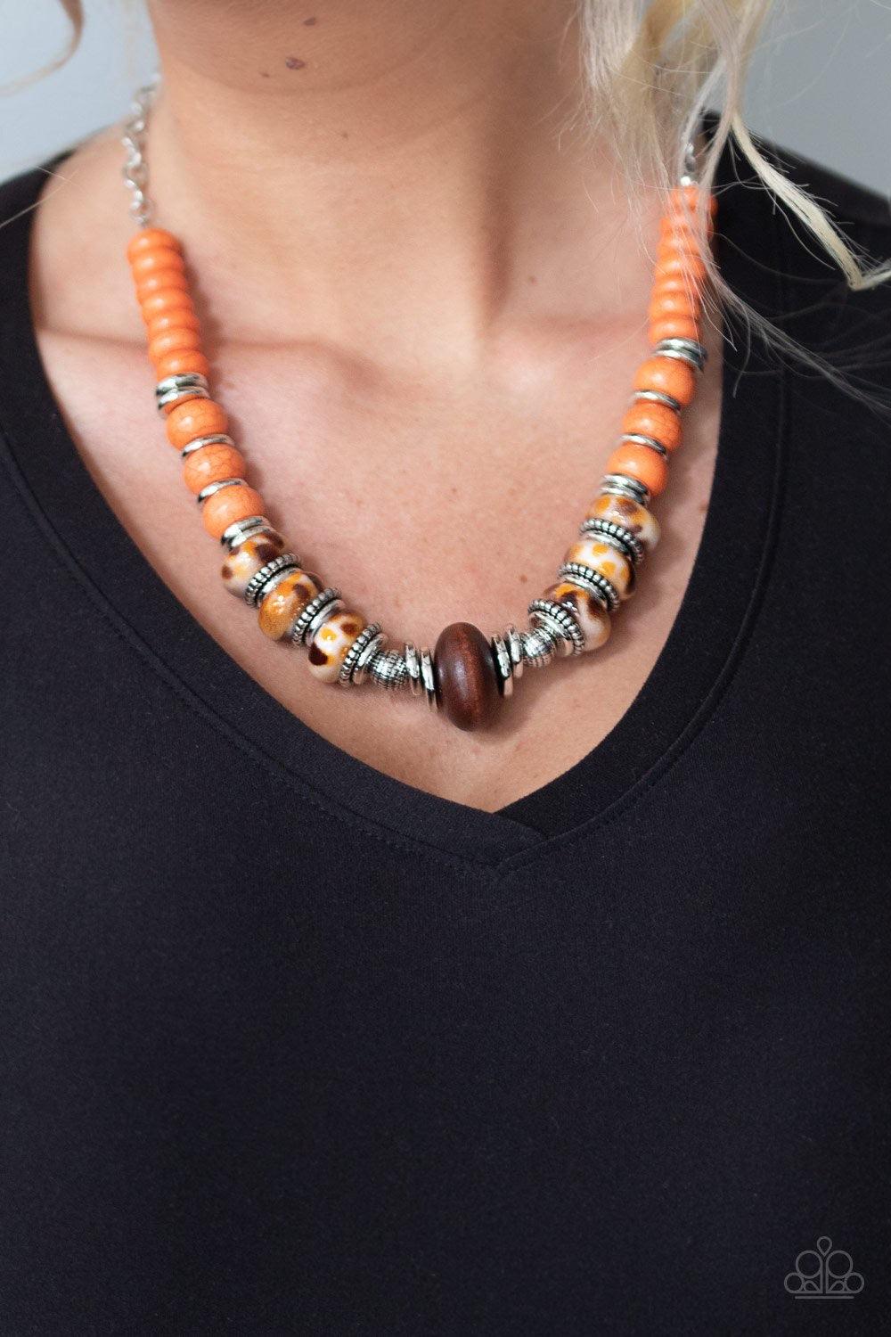 Paparazzi Accessories Desert Tranquility - Orange An earthy collection of dainty silver accents, rounded orange stone beads, and spotted ceramic-like beads are threaded along an invisible wire below the collar. An earthy wooden bead adorns the center, add