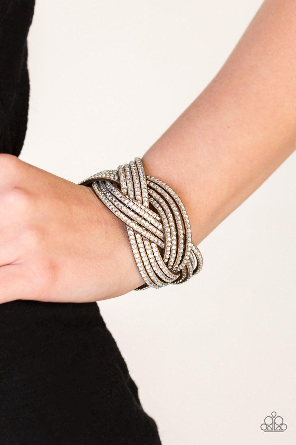 Paparazzi Accessories Big City Shimmer - Brown Glassy white rhinestones are encrusted along crisscrossing strands of brown suede, creating bold shimmer around the wrist. Features an adjustable snap closure. Jewelry