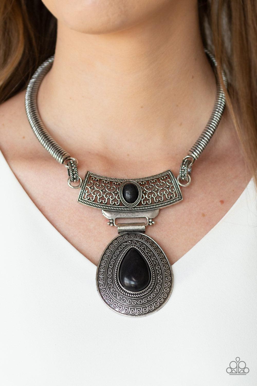 Paparazzi Accessories Prowling Prowess - Black Etched in linear textures, bowing silver bars link with an ornate silver plate dotted with an earthy black stone. Embossed in dizzying tribal inspired patterns, an oversized black stone dotted teardrop pendan