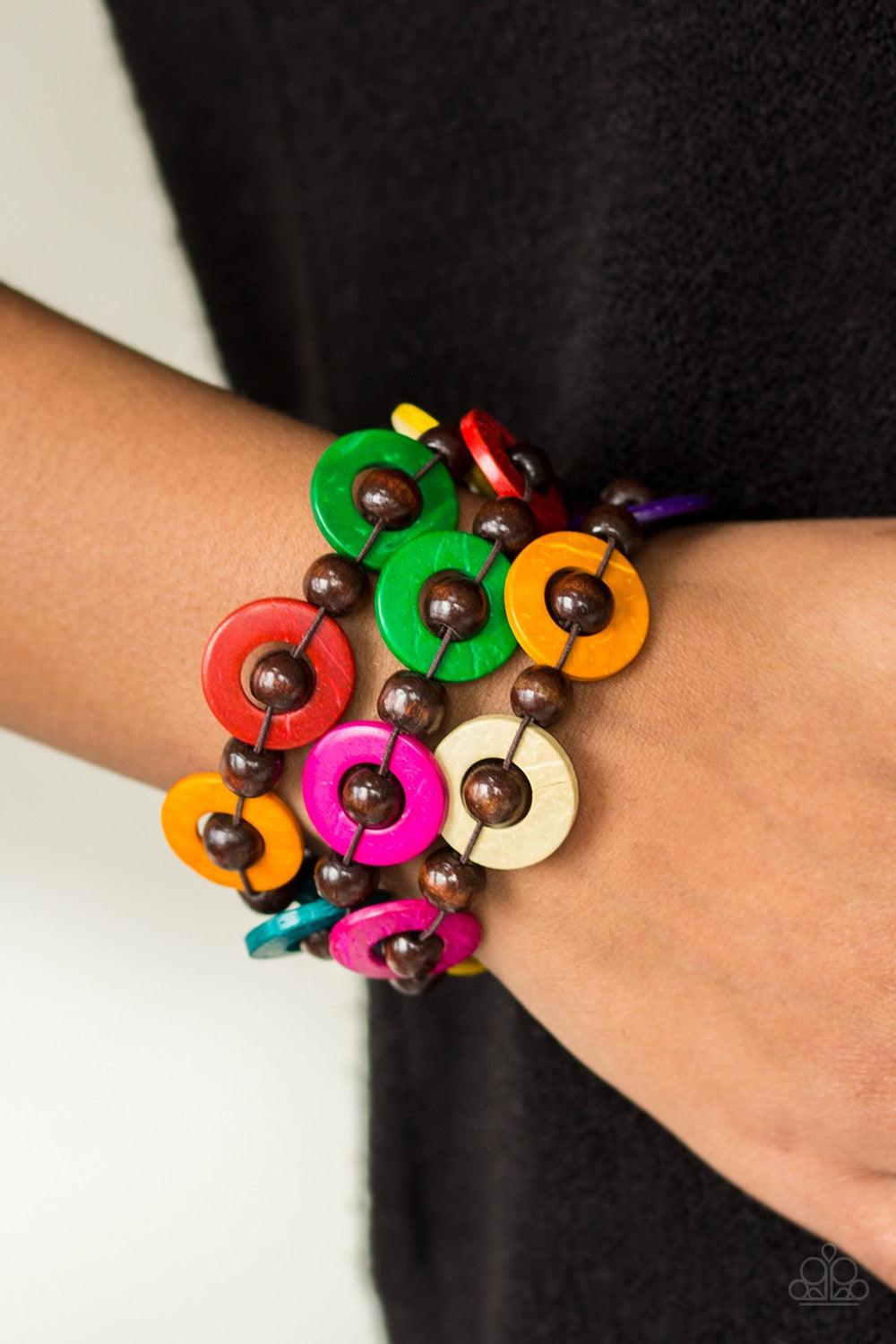 Paparazzi Accessories Cancun Catch - Multi Brushed in vivacious multicolored finishes, wooden rings and brown beads are knotted in place along three stretchy strands, creating summery layers around the wrist. Features a button loop closure. Jewelry