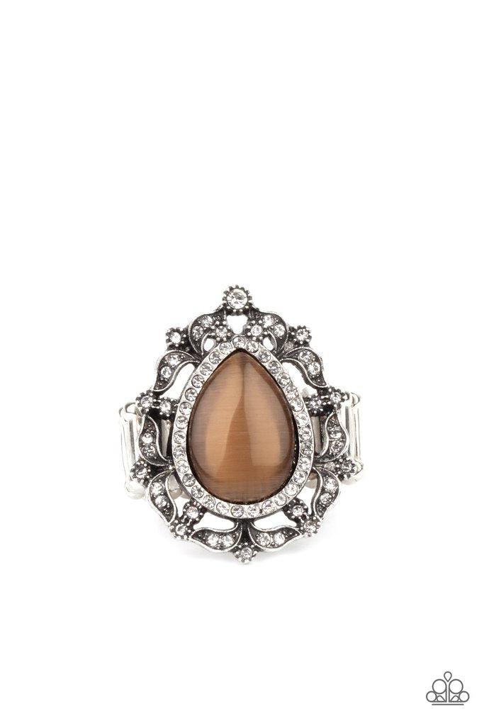 Paparazzi Accessories Iridescent Icy - Brown Dotted in glittery white rhinestones, leafy silver frames nestle around a glowing brown cat's eye teardrop center, creating a regal centerpiece atop the finger. Features a stretchy band for a flexible f Jewelry