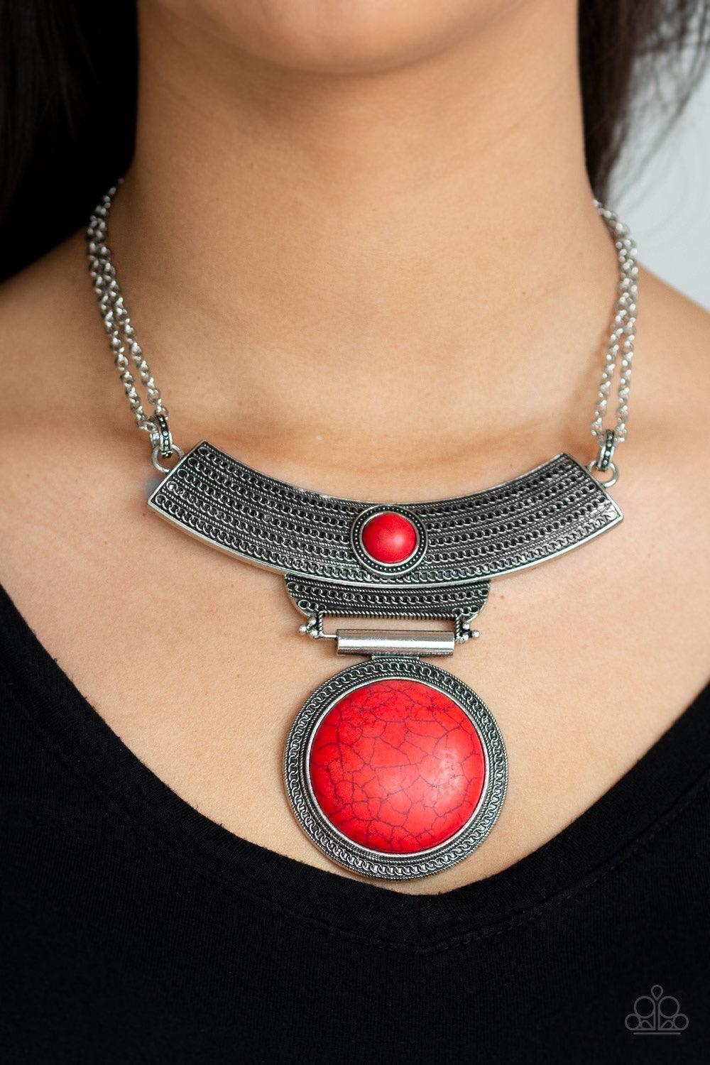 Paparazzi Accessories Lasting EMPRESS-ions - Red An antiqued silver plate, adorned in rippling circular textures, swings from the bottom of a pair of doubled silver chains. The ornate plate gives way to a dramatic red stone pendant bordered by tribal insp