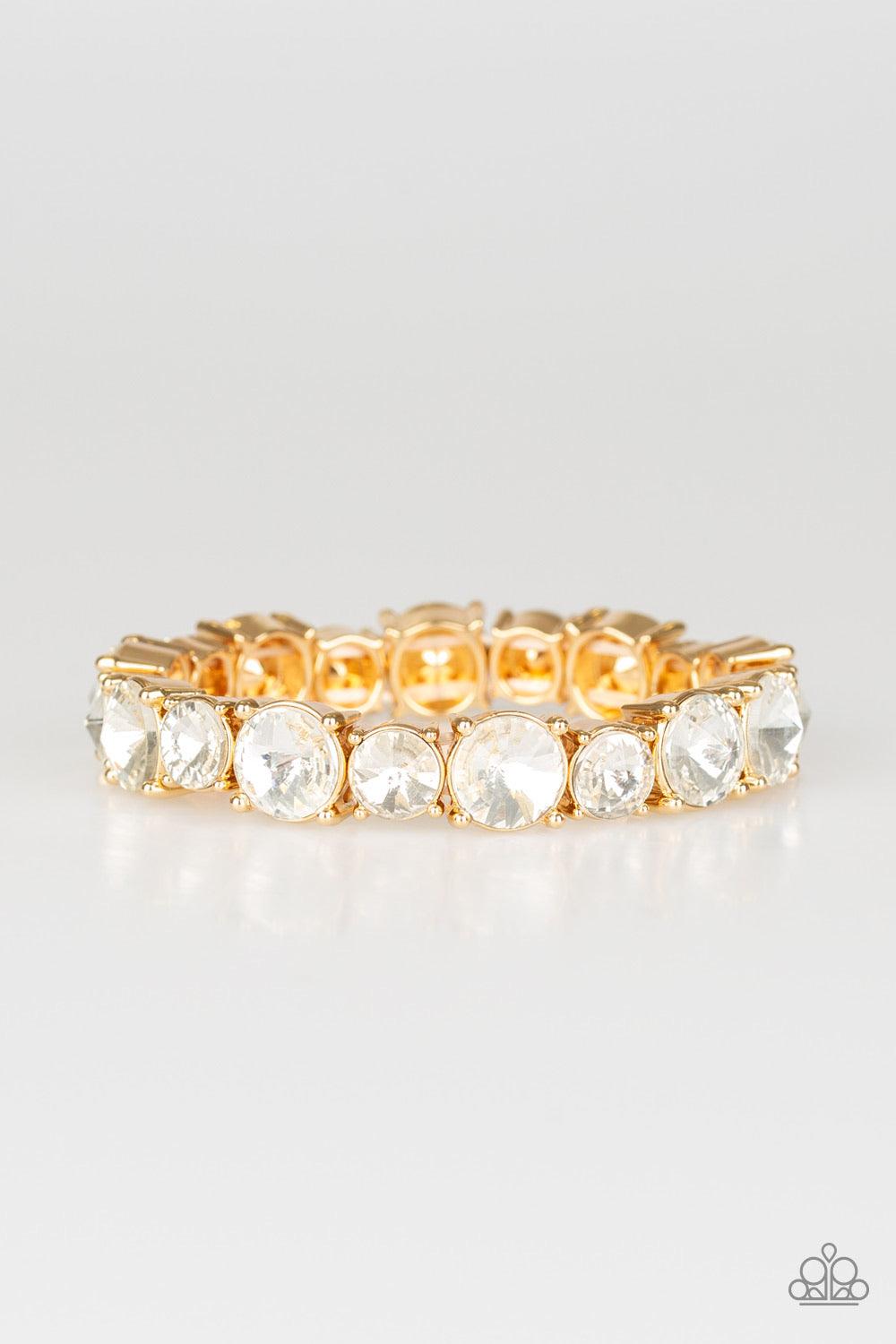 Paparazzi Accessories Born To Bedazzle - Gold An assortment of oversized white rhinestones are pressed into gold square frames and threaded along stretchy bands, creating a blinding sparkle around the wrist. Jewelry