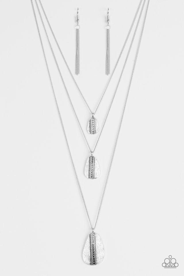 Paparazzi Accessories Sonoran Storm - Silver Gradually increasing in size, asymmetrical silver teardrops drip down the chest, creating rustic layers. The glistening teardrops are etched and studded down the center, adding tactile texture to the tribal ins