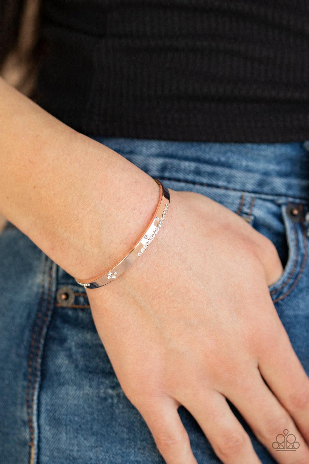 Paparazzi Accessories Dainty Dazzle - Rose Gold Glassy white rhinestones are sprinkled across the front of a dainty rose gold cuff for a refined look. Jewelry