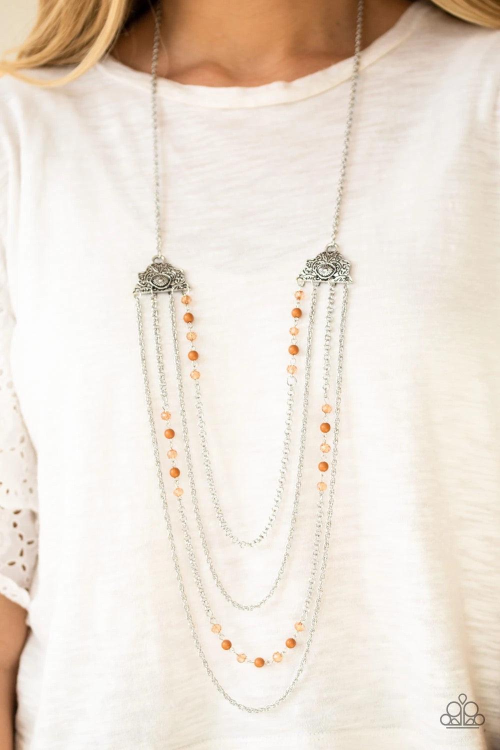 Paparazzi Accessories Pharaoh Finesse - Brown Attached to two ornate floral silver fittings, shimmery silver chains and strands of polished brown and glassy crystal-like beads cascade across the chest for a whimsically layered look. Features an adjustable