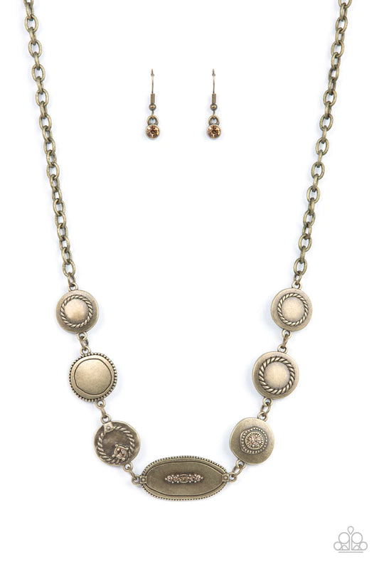 Paparazzi Accessories Uniquely Unconventional - Brass Sporadically dotted in dainty topaz rhinestones and metallic rope-like texture, an asymmetrical assortment of rustic brass frames delicately link below the collar for a one-of-a-kind shimmer. Features