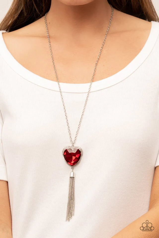 Paparazzi Accessories Finding My Forever - Red Bordered in a ribbon of glassy white rhinestones, an oversized red heart-shaped gem seemingly floats at the bottom of an extended silver chain. A shimmery silver chain tassel dances from the bottom of the spa