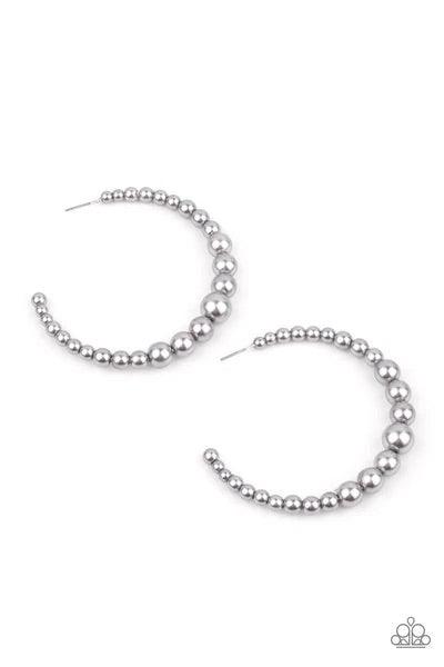 Paparazzi Accessories Glamour Graduate - Silver Gradually increasing in size at the center, a classic row of pearly silver beads are threaded along an oversized hoop for a posh finish. Earring attaches to a standard post fitting. Hoop measures approximate