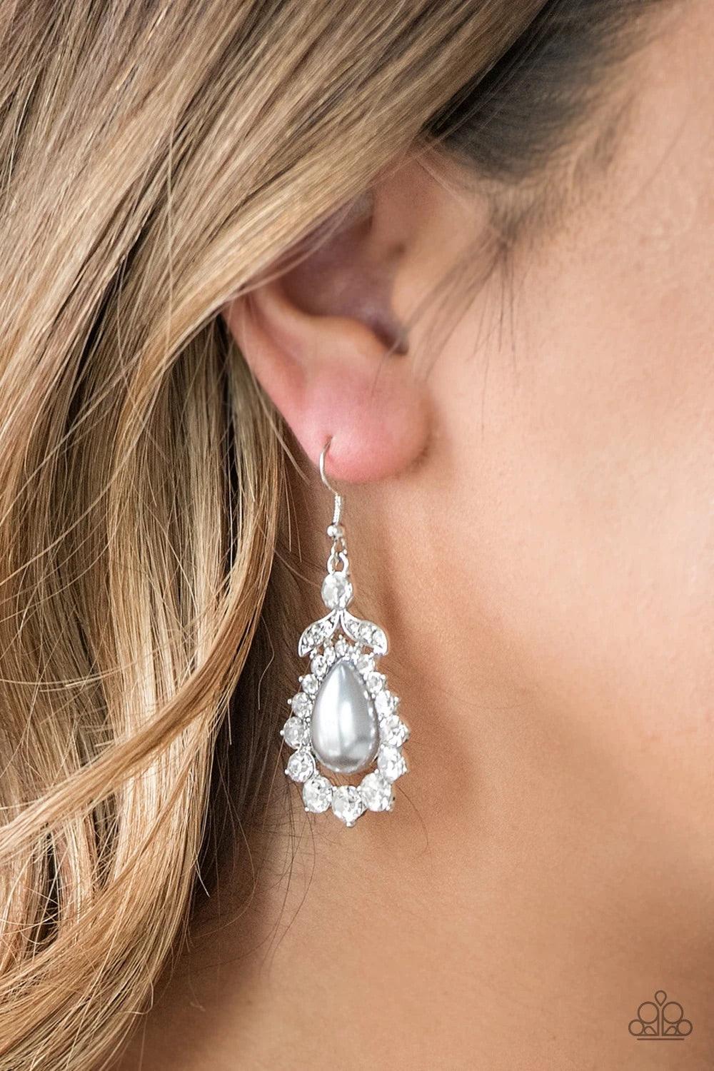Paparazzi Accessories Award Winning Shimmer - Silver Gradually increasing in size near the center, glassy white rhinestones join around a pearly silver teardrop center. A solitaire white rhinestone and leafy silver frame crown the top of the frame for a g