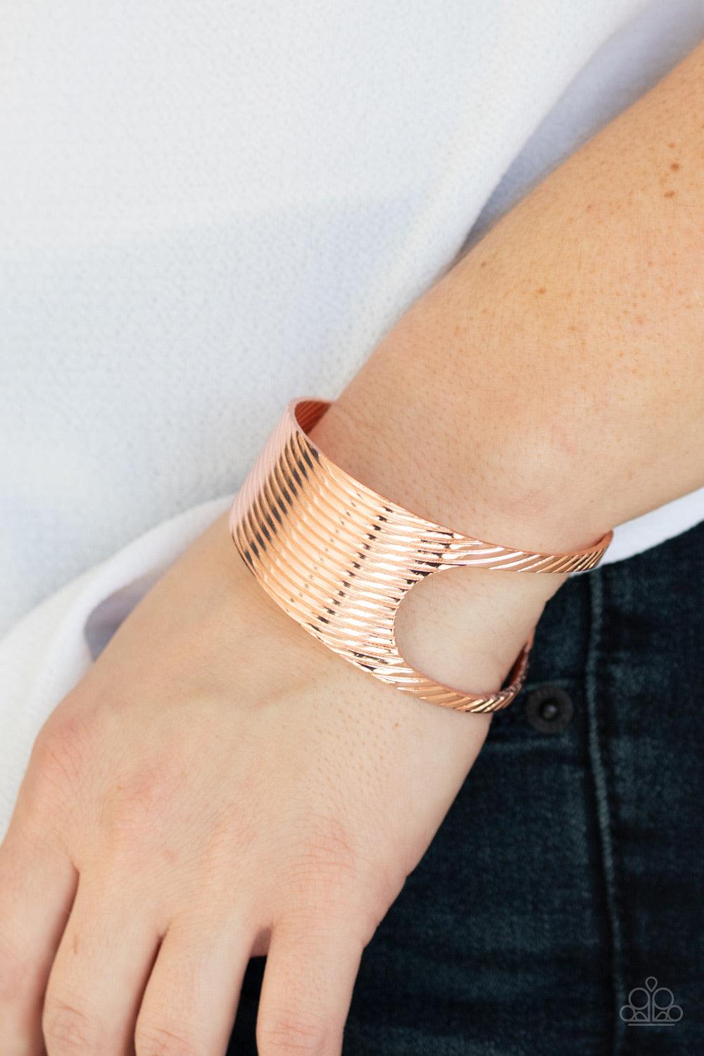 Paparazzi Accessories What GLEAMS Are Made of - Copper Stamped in a slanted linear pattern, a shiny copper cuff featuring an airy asymmetrical cutout wraps around the cuff for a bold industrial look. Bracelets