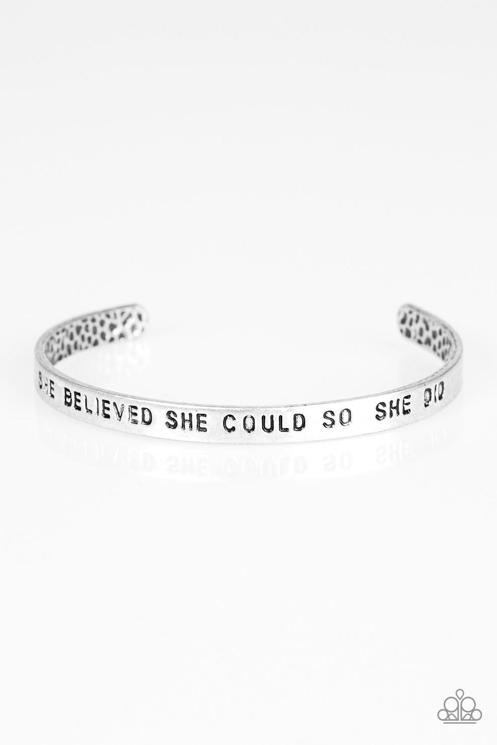 Paparazzi Accessories She Believed She Could - Silver A silver cuff wraps around the wrist in a bright and casual fashion. Painted in a black hue, the phrase “She believed she could so she did” runs horizontally across the cuff for an inspirational finish