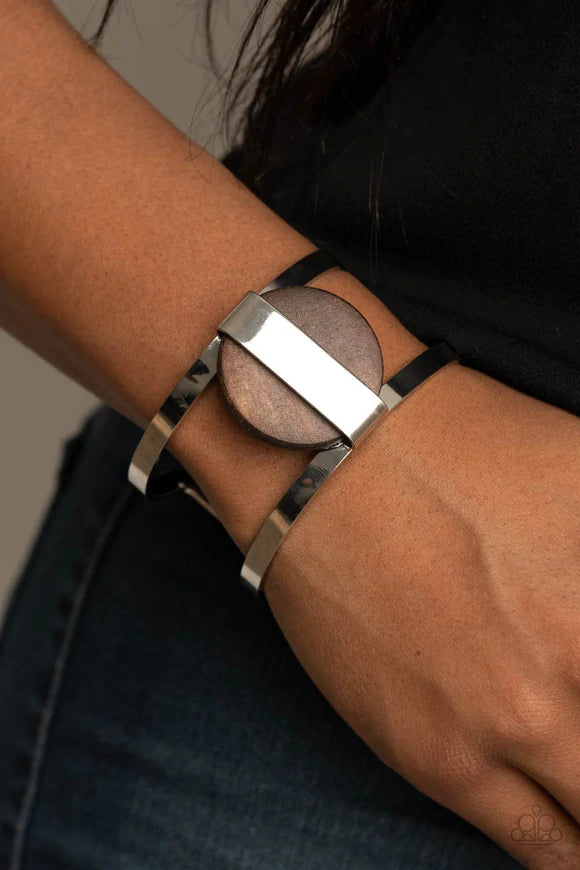 Paparazzi Accessories Organic Fusion - Brown A shiny silver frame wraps around an earthy wooden disc, creating an abstract centerpiece atop a bold silver cuff for a trendy finish. Sold as one individual bracelet. Bracelets
