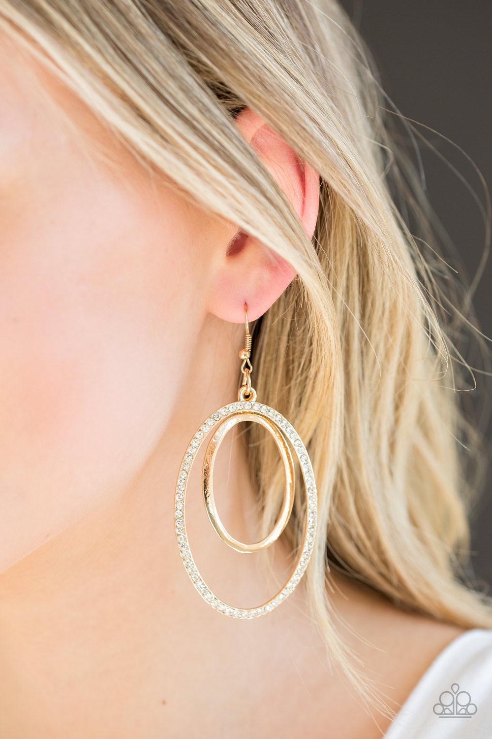 Paparazzi Accessories Wrapped in Wealth - Gold A glistening gold hoop swings from the top of a larger gold hoop radiating with glassy white rhinestones for a refined look. Earring attaches to a standard fishhook fitting. Jewelry