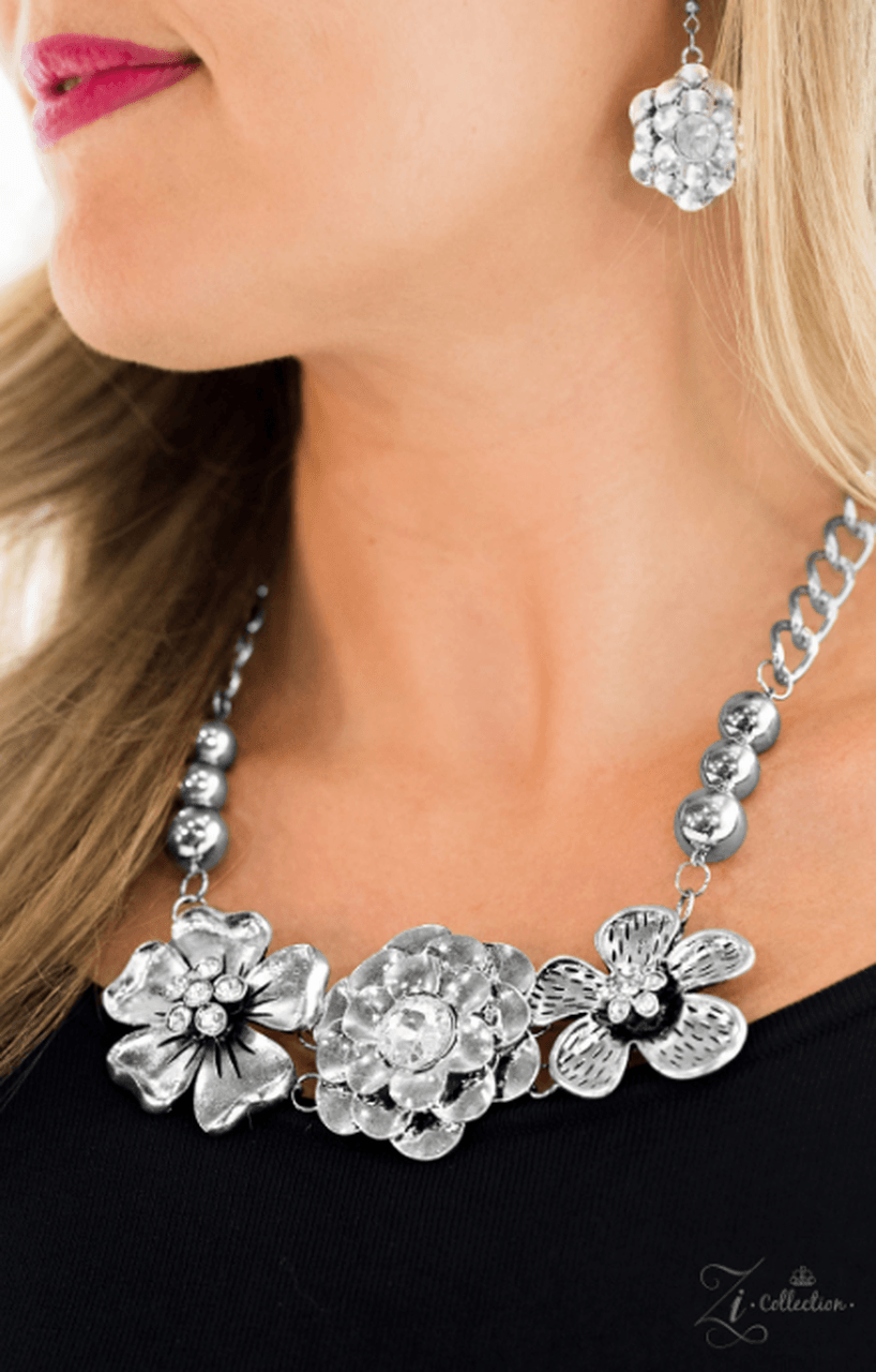 Paparazzi Accessories Abloom Strands of bulky silver chain and polished silver beads give way to three flower frames below the collar. Brushed in lifelike floral detail, the glistening flowers feature glittery rhinestone centerpieces for a timeless finish