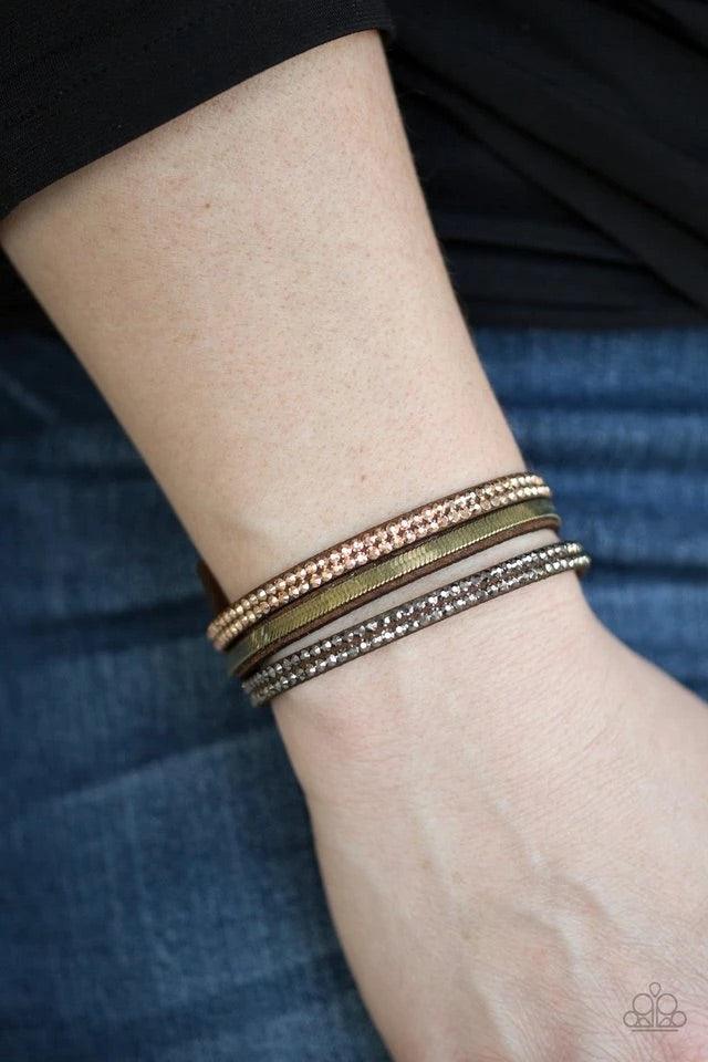 Paparazzi Accessories I Mean Business - Multi A brown suede band is spliced into three strands featuring rows of glittery hematite rhinestones, flat brass chain, and faceted metallic rhinestones for a glamorous look. Features an adjustable snap closure. S