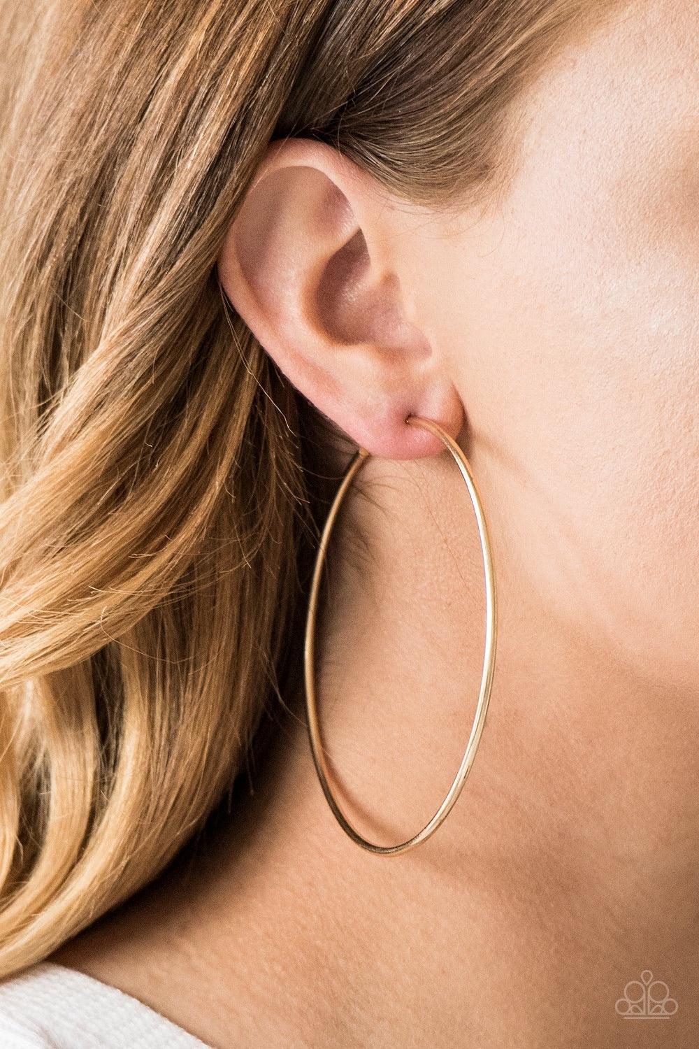 Paparazzi Accessories Meet Your Maker - Gold A skinny ribbon of gold curls into a bold hoop for a dramatic look. Earring attaches to a standard post fitting. Hoop measures 3” in diameter. Jewelry