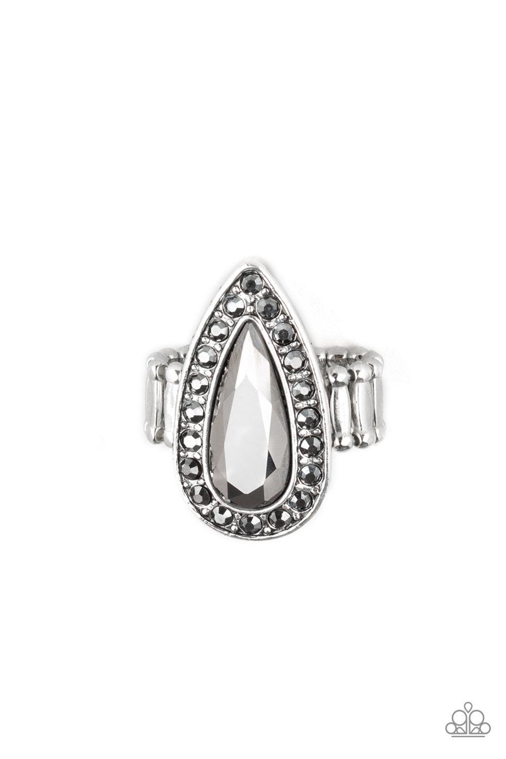 Paparazzi Accessories Majestic Mayhem - Silver An oversized hematite teardrop gem is pressed in the center of a glistening silver teardrop frame radiating with glittery hematite rhinestones for a fierce look. Features a stretchy band for a flexible fit. J