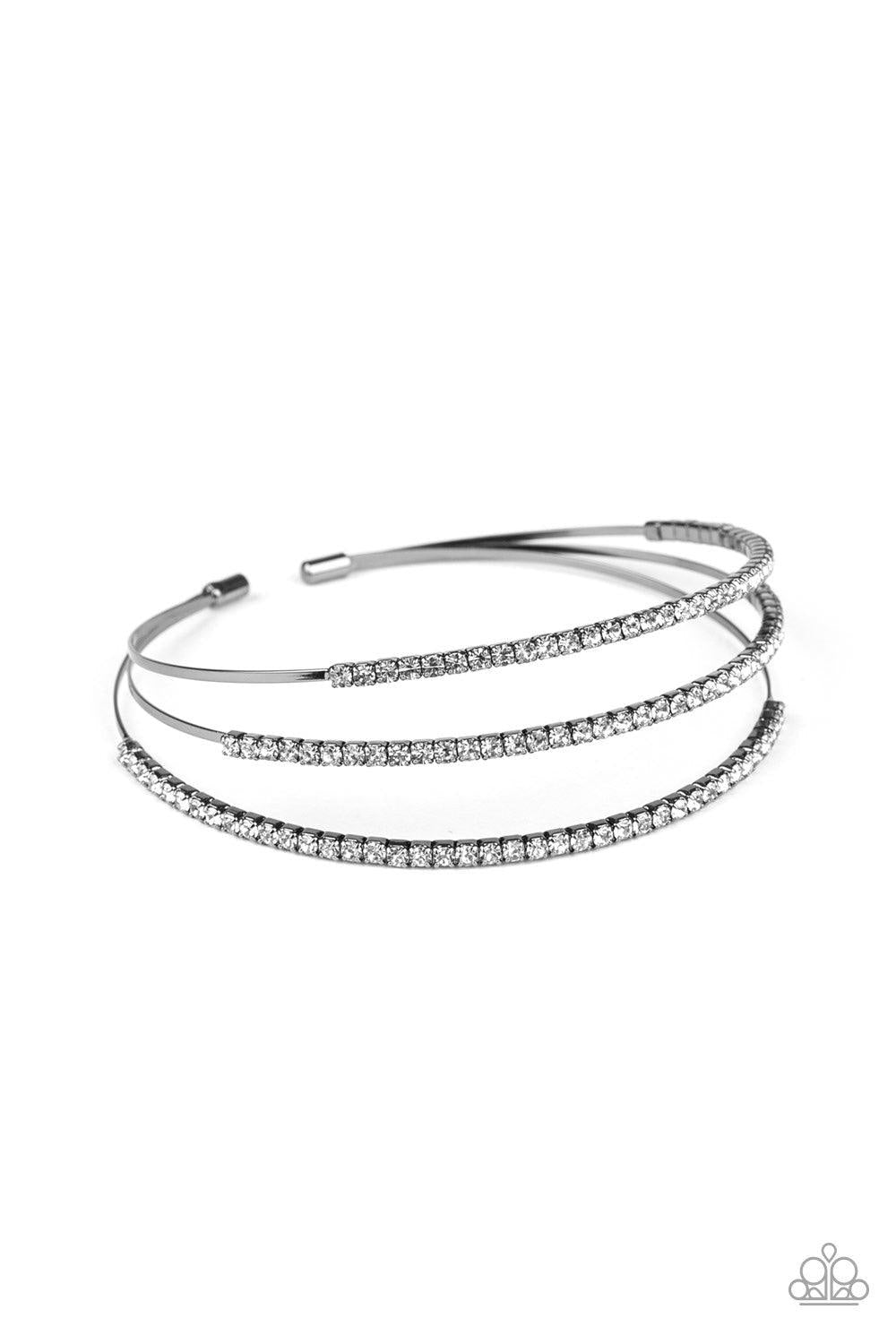 Paparazzi Accessories Iridescently Infatuated - Black Sections of glittery white rhinestones are encrusted along the tops of three dainty gunmetal bars that coalesce into a glitzy cuff around the wrist. Jewelry